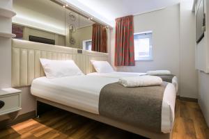 a bedroom with two beds and a window at Point A Hotel London Shoreditch in London
