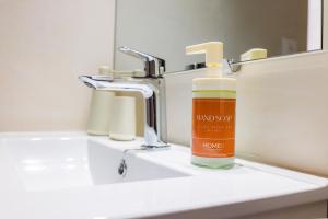 a bottle of hand soap sitting on a bathroom sink at Apt Libelule in Tourrettes-sur-Loup +17 photos
