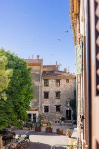 a large stone building is seen from a window at Apt Libelule in Tourrettes-sur-Loup