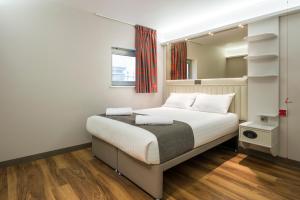a bedroom with a bed and a window at Point A Hotel London Shoreditch in London