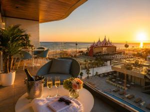 a room with a table with wine glasses and a view of the beach at FIRST RESIDENCe in Mamaia