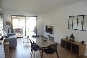 a living room with a table and chairs at Escapade Bassin - Spa Privé - Maison 6 Pers in Audenge