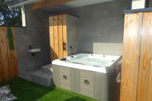 a bathroom with a bath tub with green grass at Escapade Bassin - Spa Privé - Maison 6 Pers in Audenge