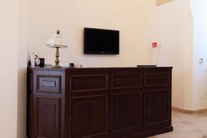 a large wooden cabinet with a television on a wall at Dimora Mennuti in Monteparano