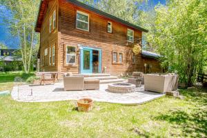 a log home with a patio with chairs and a table at Red Elephant | 4BR - Fire Pit - River & Downtown in Hailey