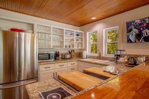 a kitchen with white cabinets and a stainless steel refrigerator at Red Elephant | 4BR - Fire Pit - River & Downtown in Hailey +52 photos