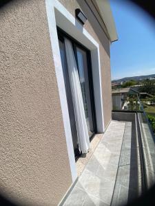 a window with a curtain on the side of a building at Arval Rooms in Vlorë