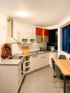 a kitchen with white cabinets and a wooden table at Monteur- und Ferienunterkunft Ludwigsfelde in Ludwigsfelde