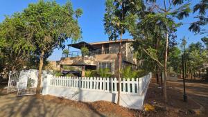 a house with a white fence in front of it at Coco Villa with Private Pool in Karjat