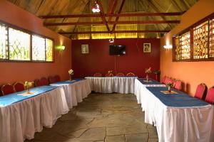 a row of tables with white table cloths in a room at Pine Breeze Getaway Lukenya in Athi River