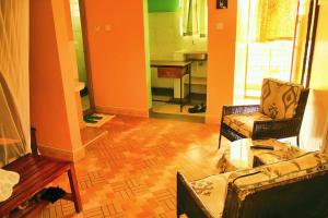 a living room with two chairs and a table at Pine Breeze Getaway Lukenya in Athi River +20 photos
