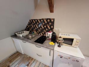 a small kitchen with a sink and a microwave at La Chambre Claire in Strasbourg