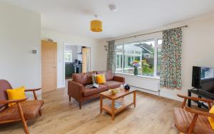 a living room with a couch and a tv at Westway - 3 Bed Coastal Bungalow with Large Garden Steps from Colwell Bay Beach in Freshwater