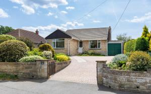 a house with a brick driveway and a green garage at Westway - 3 Bed Coastal Bungalow with Large Garden Steps from Colwell Bay Beach in Freshwater