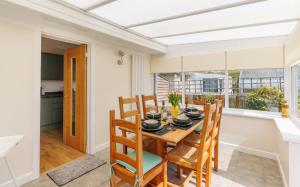 a kitchen and dining room with a table and chairs at Westway - 3 Bed Coastal Bungalow with Large Garden Steps from Colwell Bay Beach in Freshwater