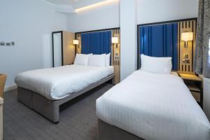 two beds in a hotel room next to each other at Best Western Victoria Palace in London