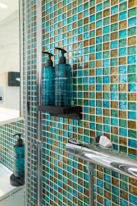 a bathroom with blue tiles on the wall at Best Western Victoria Palace in London +208 photos
