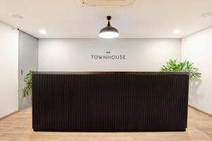 a reception desk in a room with a sign that reads the townhouse at Hotel O Crowninn in Faridabad