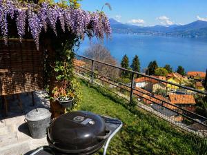 a grill sitting on the grass with a view of a lake at Casa Coccinella in Oggebbio