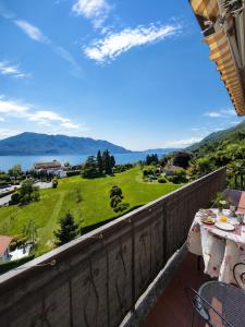 a balcony with a view of the lake and mountains at Casa Coccinella in Oggebbio