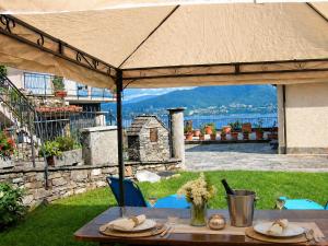 a table under an umbrella on a patio at Casa Coccinella in Oggebbio