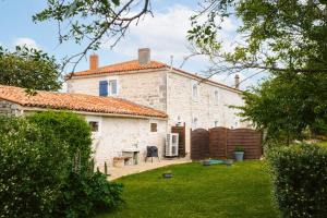a large white stone house with a yard at Gîte Les Bougrines - Marais in Fontaines
