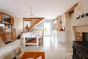 a kitchen and living room with a table and a fireplace at Gîte Les Bougrines - Marais in Fontaines +16 photos