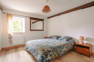 a bedroom with a bed and a window at Gîte Les Bougrines - Marais in Fontaines