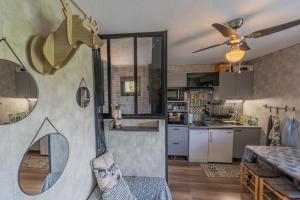 a living room with a kitchen with a ceiling fan at L'Elan in Les Angles