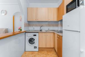 a kitchen with a washing machine and a sink at Villa Patrick in Torrevieja