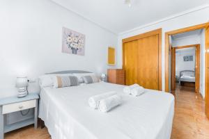 a bedroom with two beds with towels on them at Villa Patrick in Torrevieja +11 photos