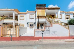 a large white house with stairs on a street at Villa Patrick in Torrevieja