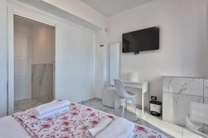 a white bedroom with a bed and a tv on the wall at Sara Venice station in Mestre +19 photos