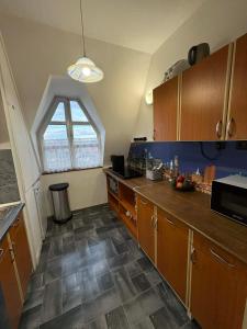 a kitchen with wooden cabinets and a window at Magaslak in Balatonalmádi