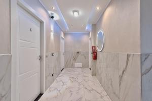 a bathroom with white walls and marble flooring at Sara Venice station in Mestre