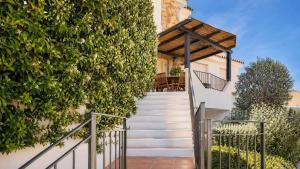 a staircase leading up to a house with a green wall at Apartment Simone in Baja Sardinia