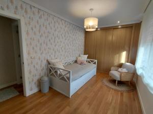a bedroom with a bed and a chair in a room at A casa de Aliciña in Sanxenxo