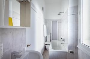 ein weißes Badezimmer mit Badewanne und Waschbecken in der Unterkunft Hotel Stella in Rapallo + 60 Fotos