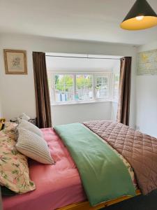 a bedroom with a bed with colorful sheets and a window at sinton House in Bransford