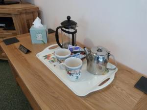 a tray with two cups and a tea kettle on a table at Tref y Nant in Castle Caereinion
