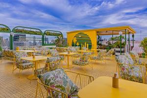 a patio with tables and chairs on a roof at Siam At Siam Design Hotel Bangkok in Bangkok