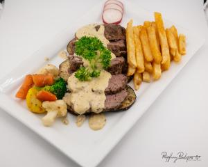 a plate of food with meat and potatoes and french fries at Sefapane Lodge and Safaris in Phalaborwa