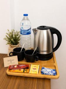 a table with a coffee maker and a tea kettle at Ars Rooms in Prizren