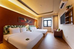 a hotel room with a large bed and a couch at NiK Hotel Hillside Da Lat in Da Lat