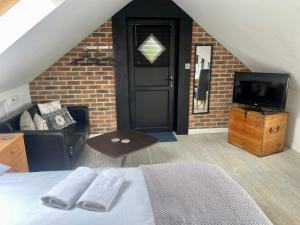 a bedroom with a bed and a tv and a brick wall at Hunters Hide Apt in Littlehampton