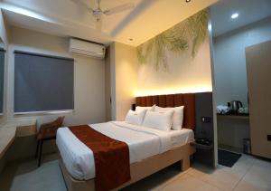 a bedroom with a bed and a large window at TheCloud Hotel in Nizāmābād