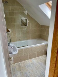 a bathroom with a bath tub and a sink at Hunters Hide Apt in Littlehampton
