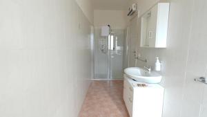a white bathroom with a sink and a shower at Country House Altavilla in Altavilla Silentina
