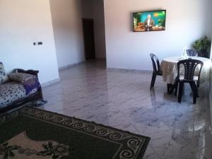 a living room with a table and a couch at Tigmi Nrayss in Essaouira