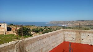 a retaining wall with a view of the ocean at Tigmi Nrayss in Essaouira +6 photos